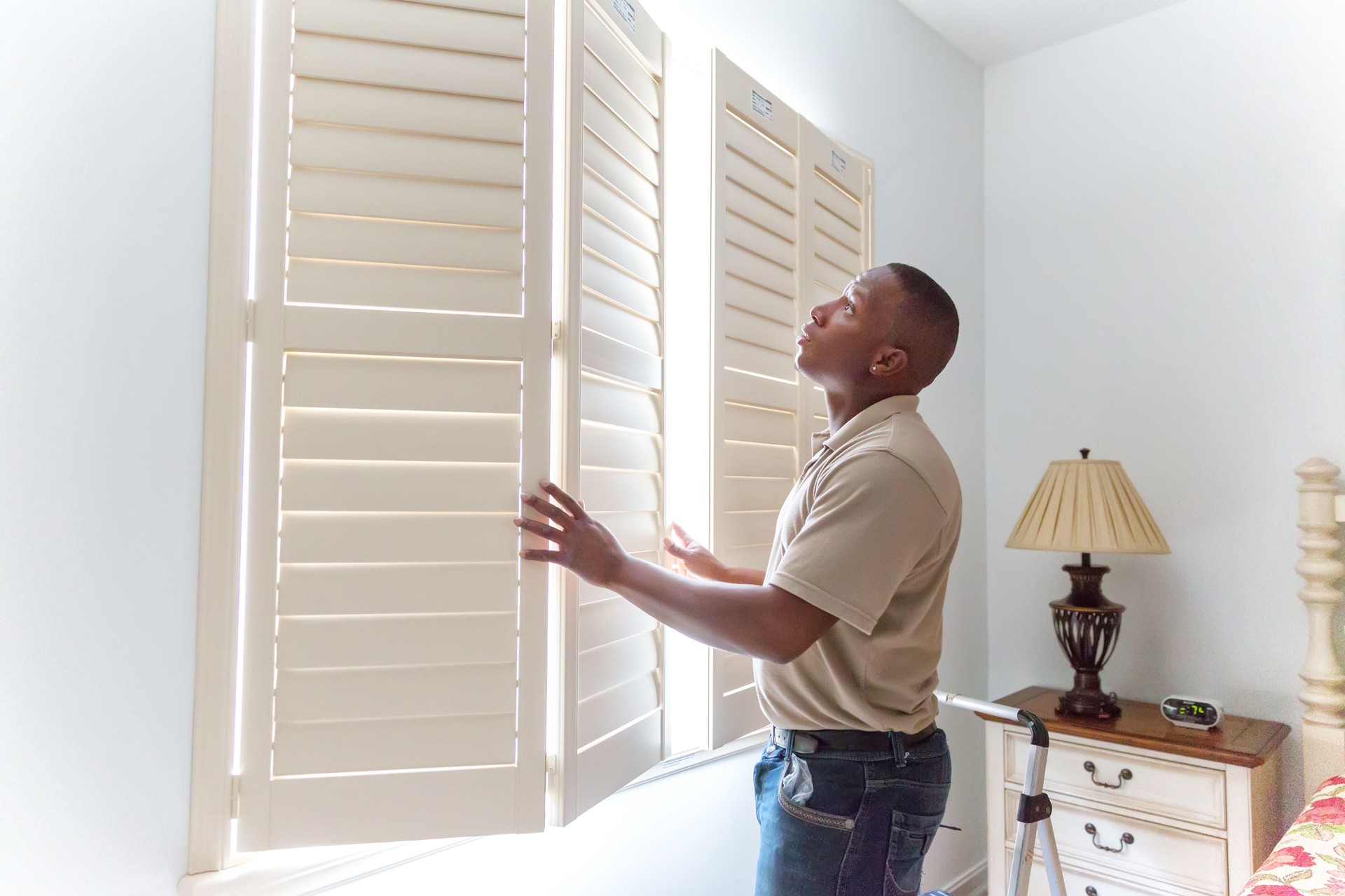 Window treatment installer installs wooden shutters